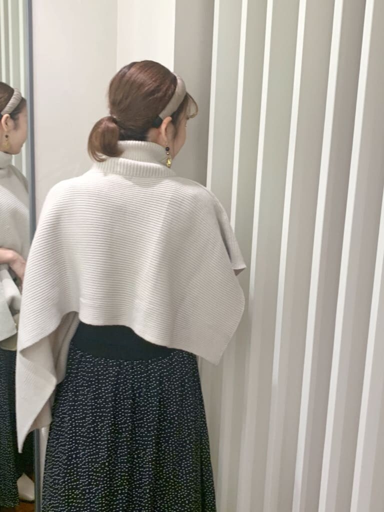 ベージュ系のブーツ、ベージュ系のハンドバッグ、ブラック系のワンピースを着用したレディースの秋コーディネートの2枚目の写真