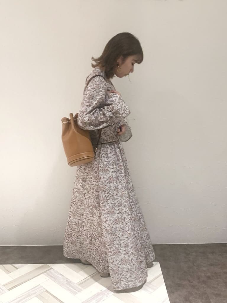 ブラウン系のワンピース、ベージュ系のブーツ、ブラウン系のバックパック/リュックを着用したレディースの秋コーディネートの6枚目の写真