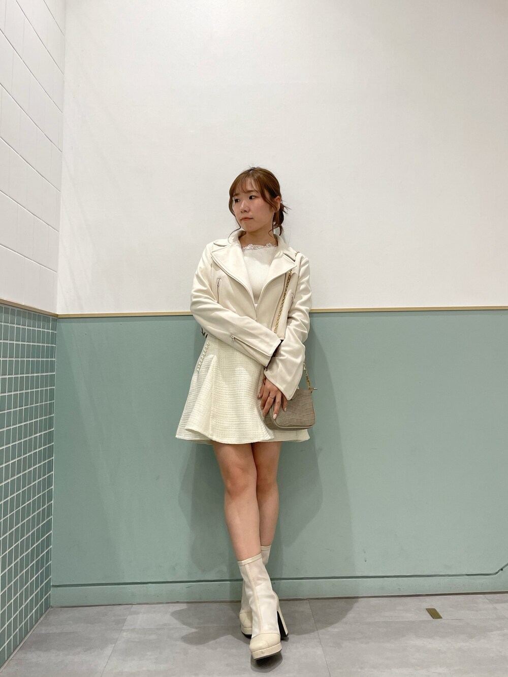 ホワイト系のライダースジャケット、ホワイト系のニット/セーター、ホワイト系のスカートを着用したレディースの春コーディネートの2枚目の写真