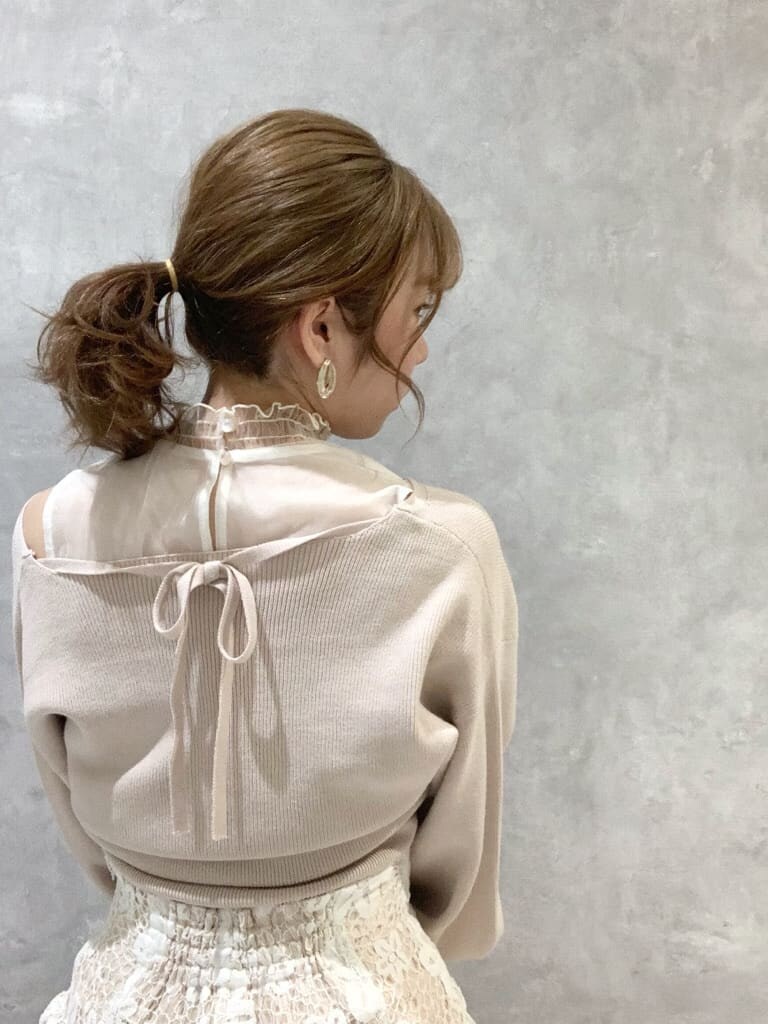 ホワイト系のスカート、ホワイト系のパンプス、ホワイト系のショルダーバッグを着用したレディースの春コーディネートの6枚目の写真