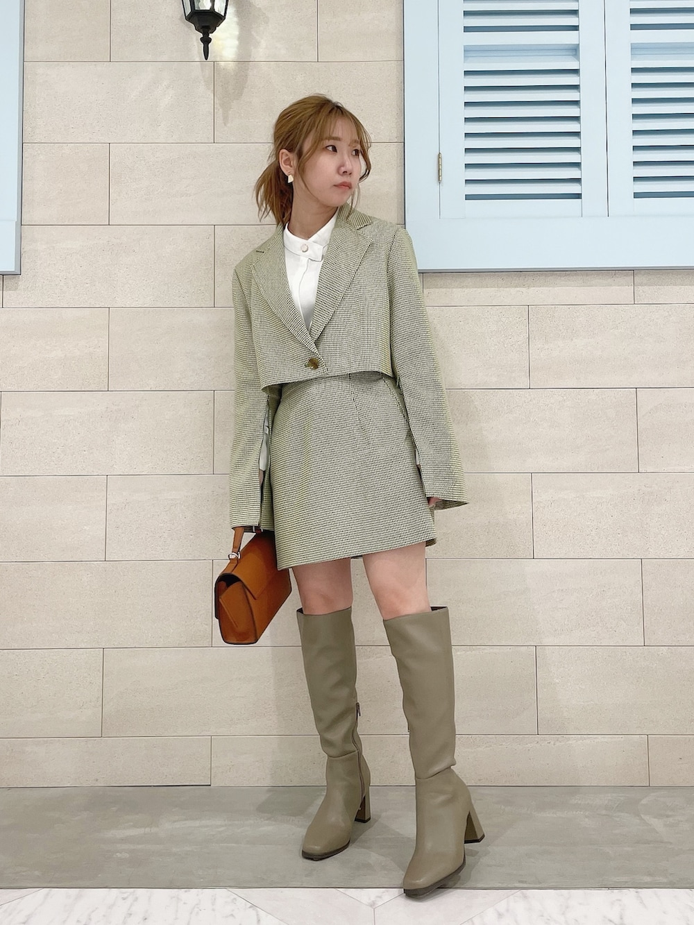 グリーン系のテーラードジャケット、ホワイト系のシャツ/ブラウス、グリーン系のスカートを着用したレディースの冬コーディネートの5枚目の写真