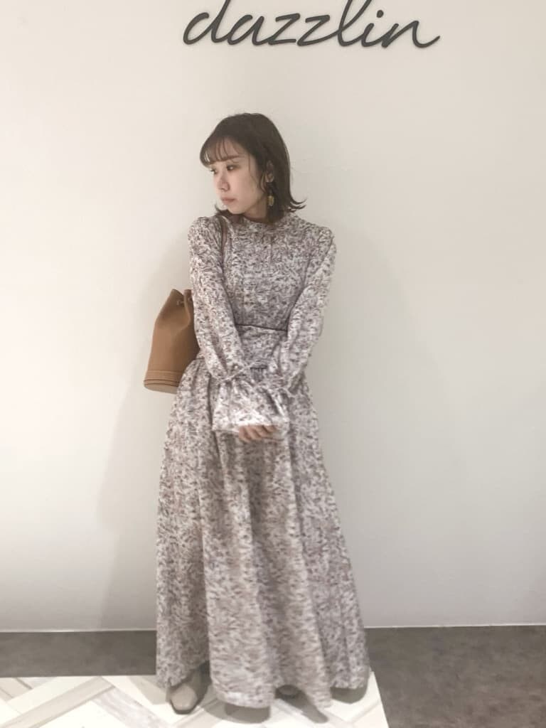 ブラウン系のワンピース、ベージュ系のブーツ、ブラウン系のバックパック/リュックを着用したレディースの秋コーディネートの3枚目の写真