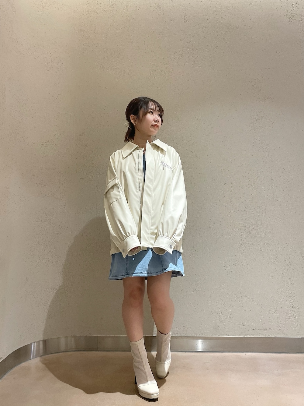 ホワイト系のブルゾン、ブルー系のワンピース、ホワイト系のブーツを着用したレディースの冬コーディネートの4枚目の写真