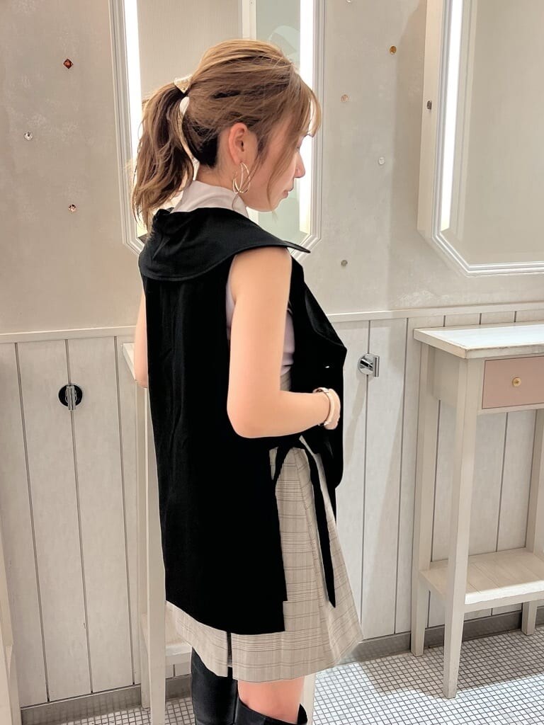 グレー系のスカート、パープル系のニット/セーター、ブラック系のベストを着用したレディースの夏コーディネートの6枚目の写真