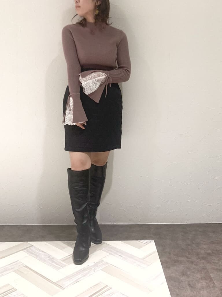 ブラック系のスカート、ブラック系のブーツ、ピンク系のニット/セーターを着用したレディースの秋コーディネートの3枚目の写真