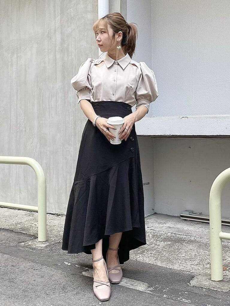 ベージュ系のシャツ/ブラウス、ブラック系のスカート、ピンク系のパンプスを着用したレディースの夏コーディネートの2枚目の写真