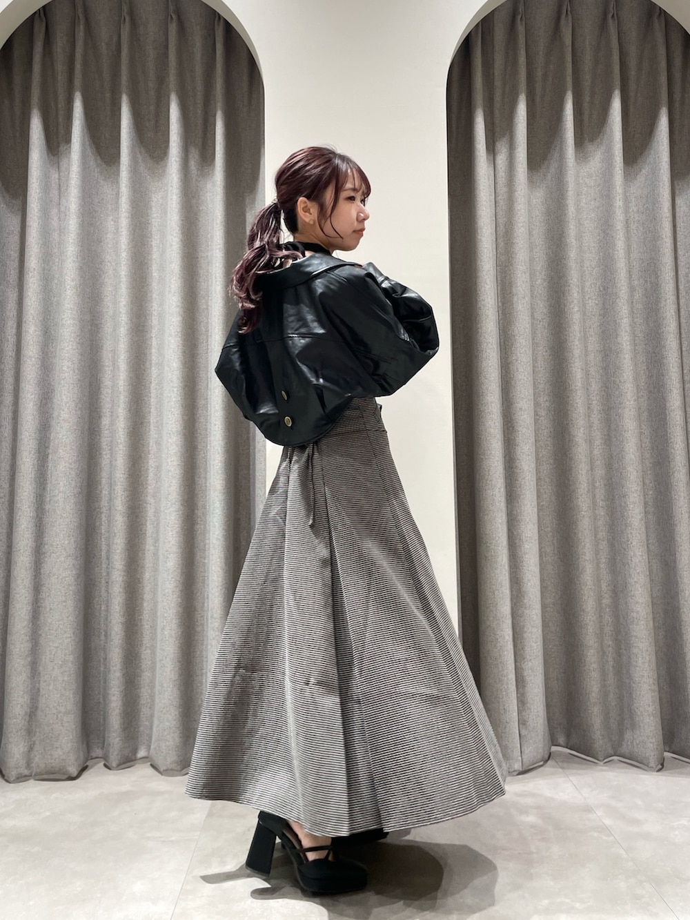 ブラック系のワンピース、ブラック系のパンプス、ブラック系のライダースジャケットを着用したレディースの秋コーディネートの4枚目の写真
