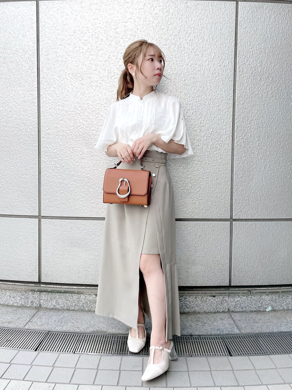 ホワイト系のシャツ/ブラウス、グリーン系のスカート、ホワイト系のパンプスを着用したレディースの春コーディネートの2枚目の写真