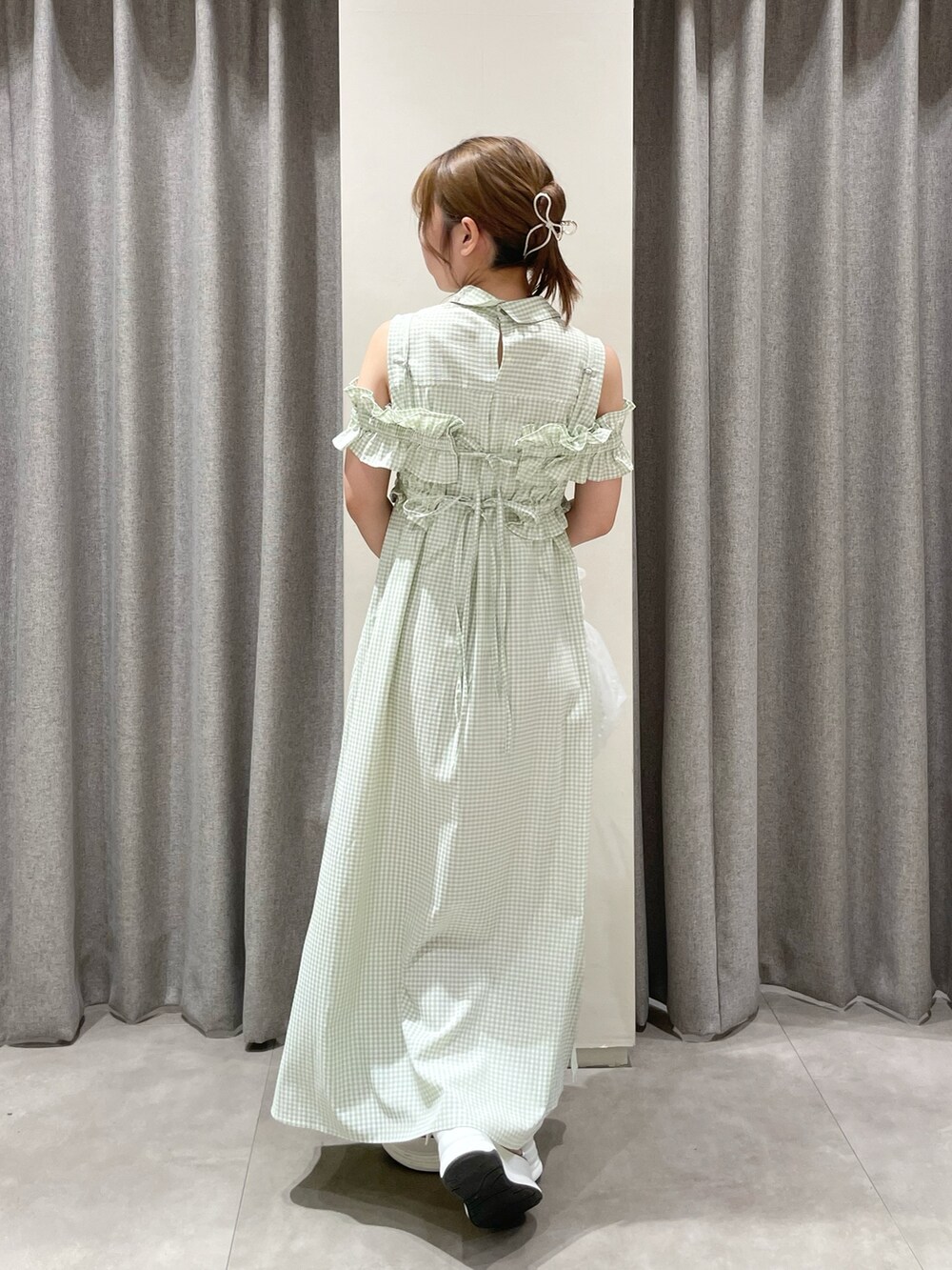 ホワイト系のハンドバッグ、ホワイト系のサンダル、グリーン系のシャツワンピースを着用したレディースの夏コーディネートの7枚目の写真