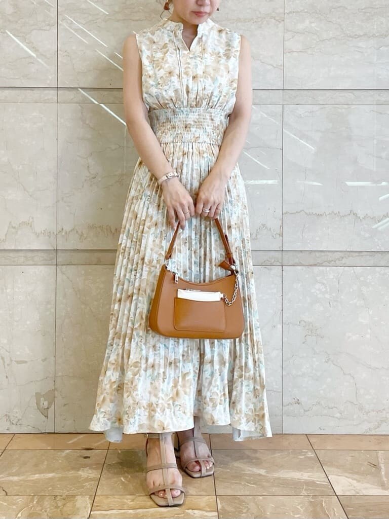 ブラウン系のハンドバッグ、ベージュ系のサンダル、オレンジ系のワンピースを着用したレディースの夏コーディネートの2枚目の写真