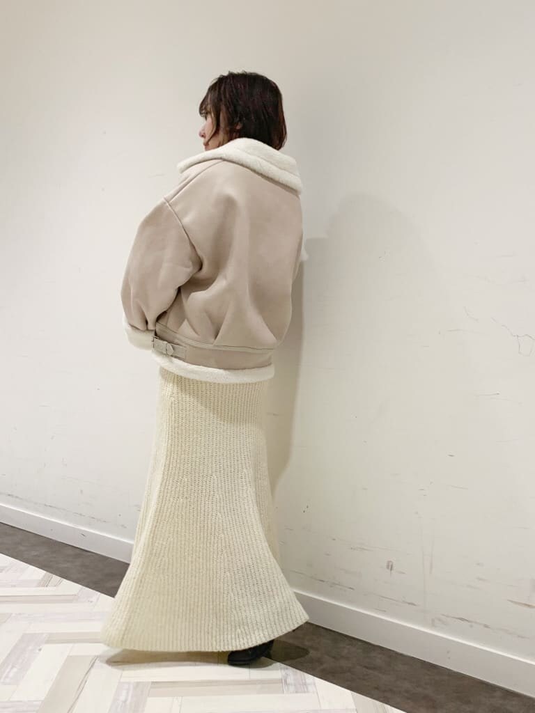 ホワイト系のワンピース、ホワイト系のブルゾン、ブラック系のブーツを着用したレディースの秋コーディネートの9枚目の写真