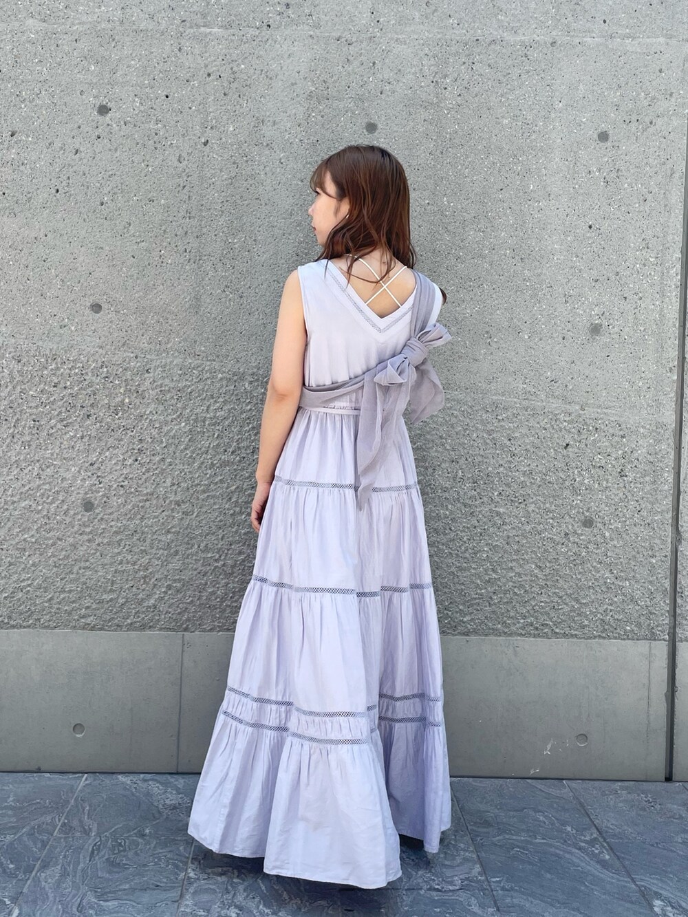 パープル系のベスト、パープル系のワンピース、シルバー系のパンプスを着用したレディースの夏コーディネートの5枚目の写真