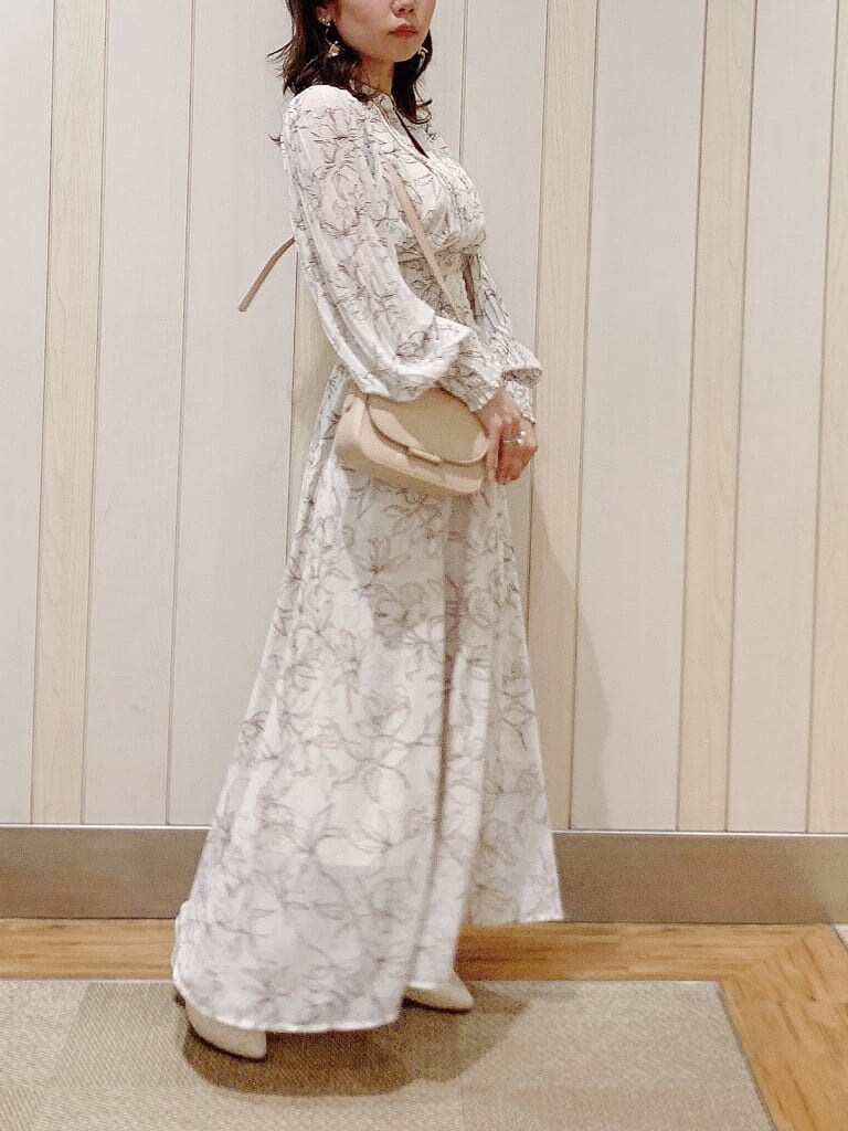 ホワイト系のワンピース、ベージュ系のパンプス、ベージュ系のショルダーバッグを着用したレディースの冬コーディネートの2枚目の写真