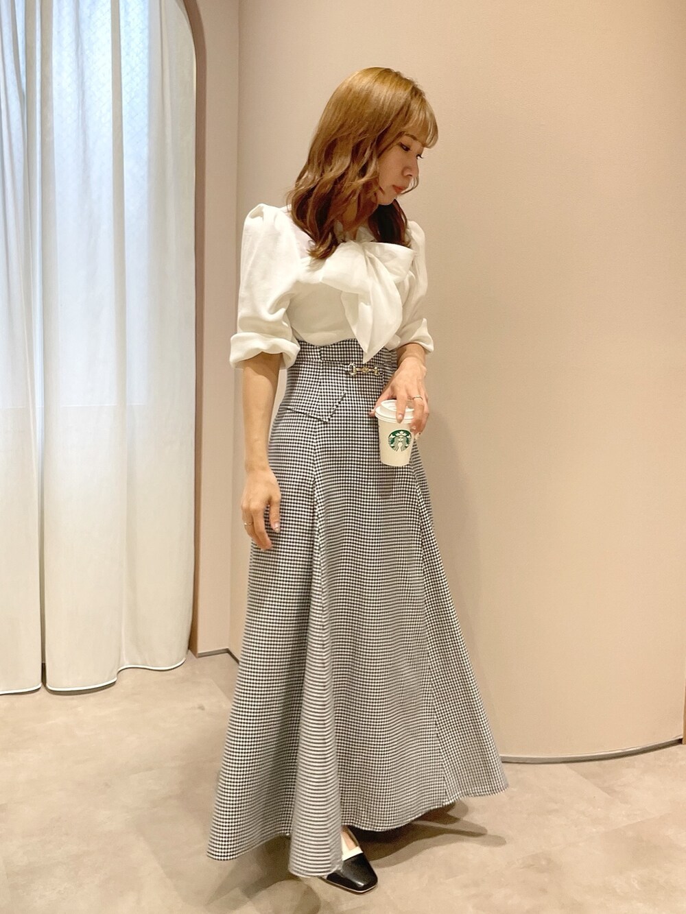 ホワイト系のニット/セーター、ブラック系のスカート、その他のパンプスを着用したレディースの冬コーディネートの2枚目の写真