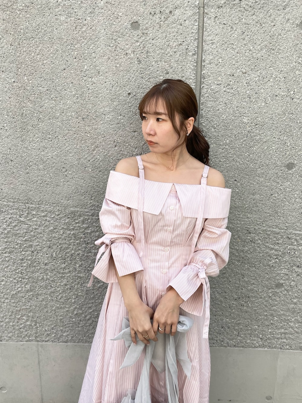 ピンク系のシャツワンピース、グレー系のベスト、ホワイト系のパンプスを着用したレディースの春コーディネートの5枚目の写真