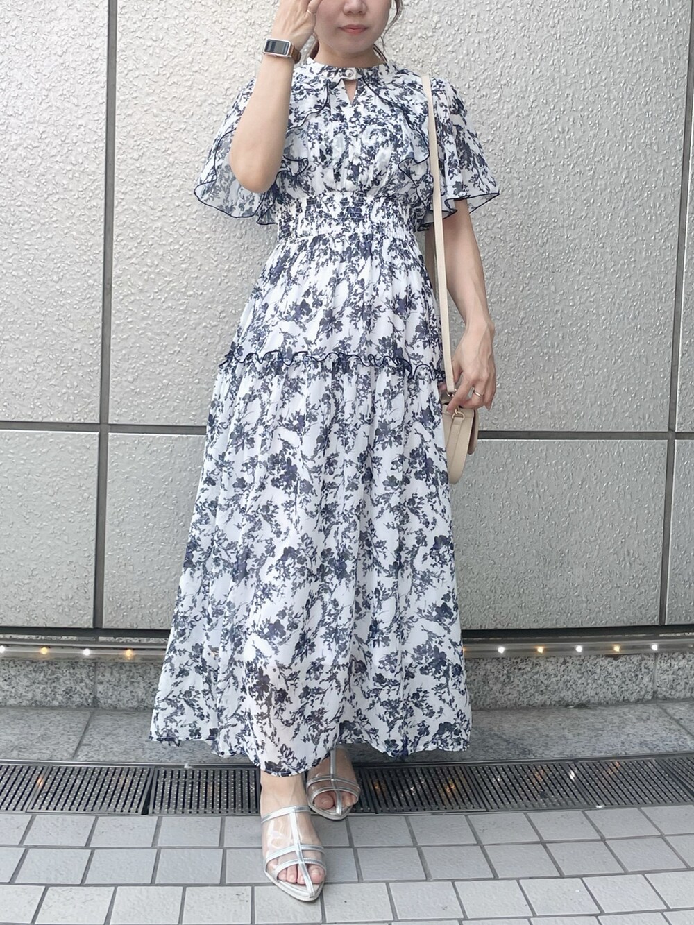 ホワイト系のワンピース、ホワイト系のハンドバッグ、シルバー系のパンプスを着用したレディースの夏コーディネートの3枚目の写真