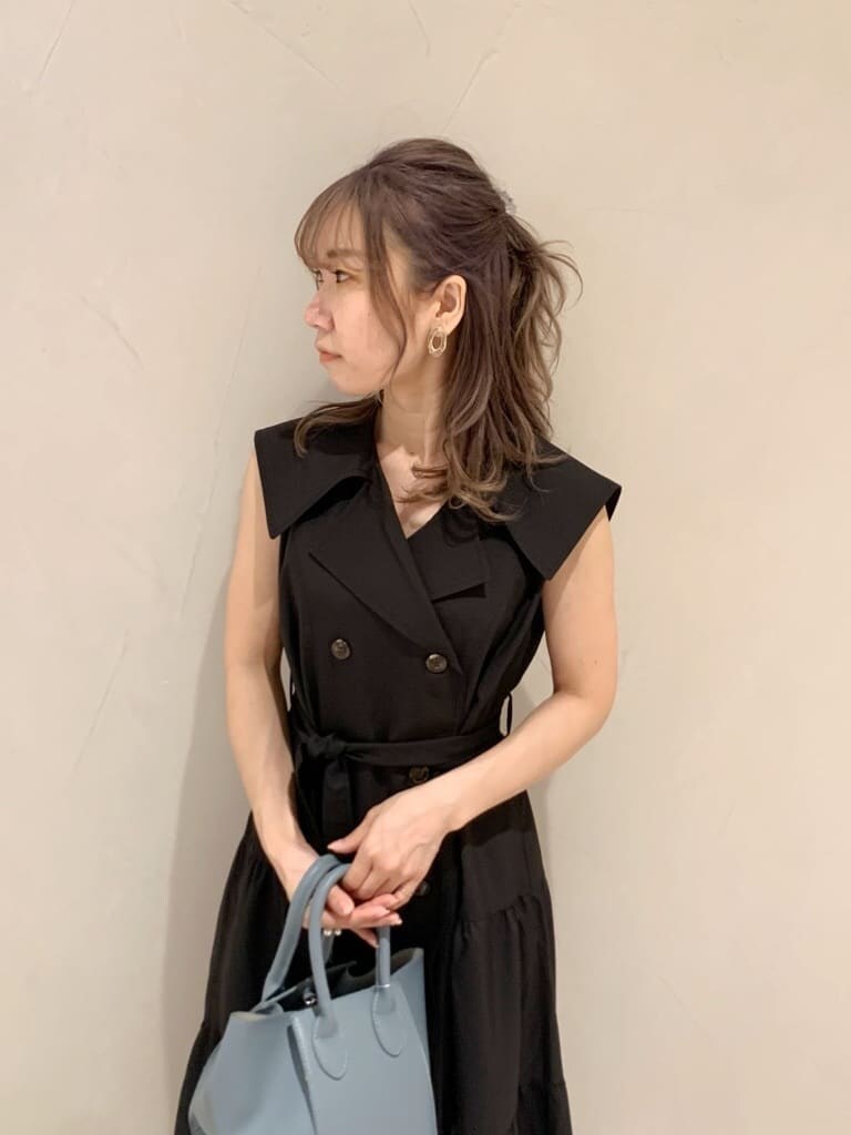 ブルー系のハンドバッグ、ブラック系のワンピース、ブラック系のサンダルを着用したレディースの春コーディネートの4枚目の写真