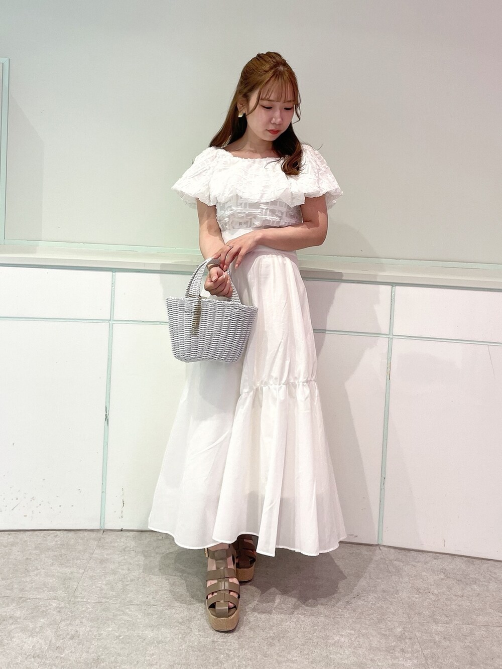ホワイト系のシャツ/ブラウス、ホワイト系のスカート、ブラウン系のサンダルを着用したレディースの夏コーディネートの2枚目の写真