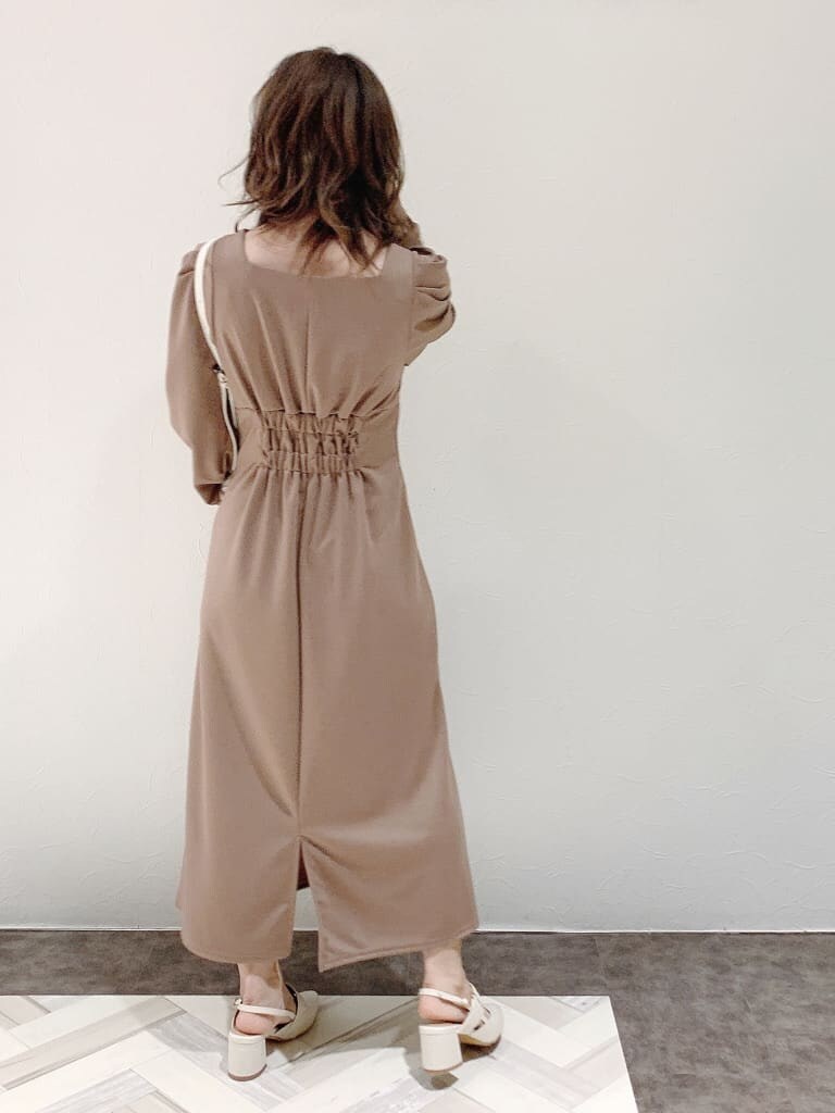 ブラウン系のワンピース、ホワイト系のパンプス、ホワイト系のショルダーバッグを着用したレディースの冬コーディネートの7枚目の写真