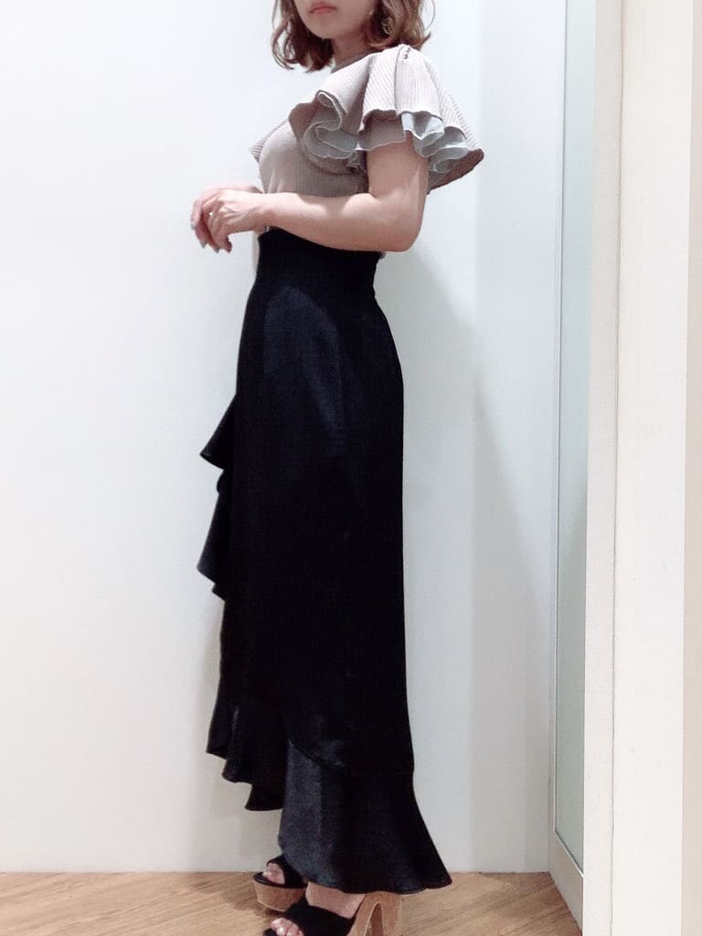 ブラック系のスカート、ブラック系のサンダル、グレー系のTシャツ/カットソーを着用したレディースの夏コーディネートの2枚目の写真