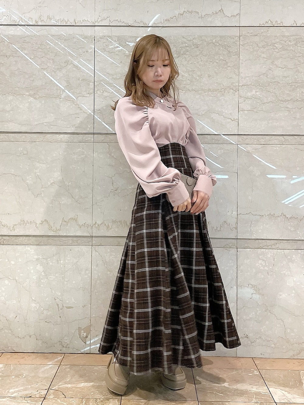 ピンク系のシャツ/ブラウス、ブラウン系のスカート、ベージュ系のローファーを着用したレディースの冬コーディネートの2枚目の写真