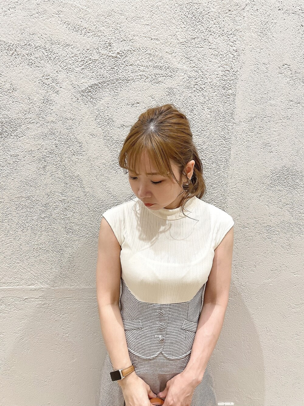 イエロー系のハンドバッグ、ホワイト系のワンピース、シルバー系のパンプスを着用したレディースの夏コーディネートの5枚目の写真