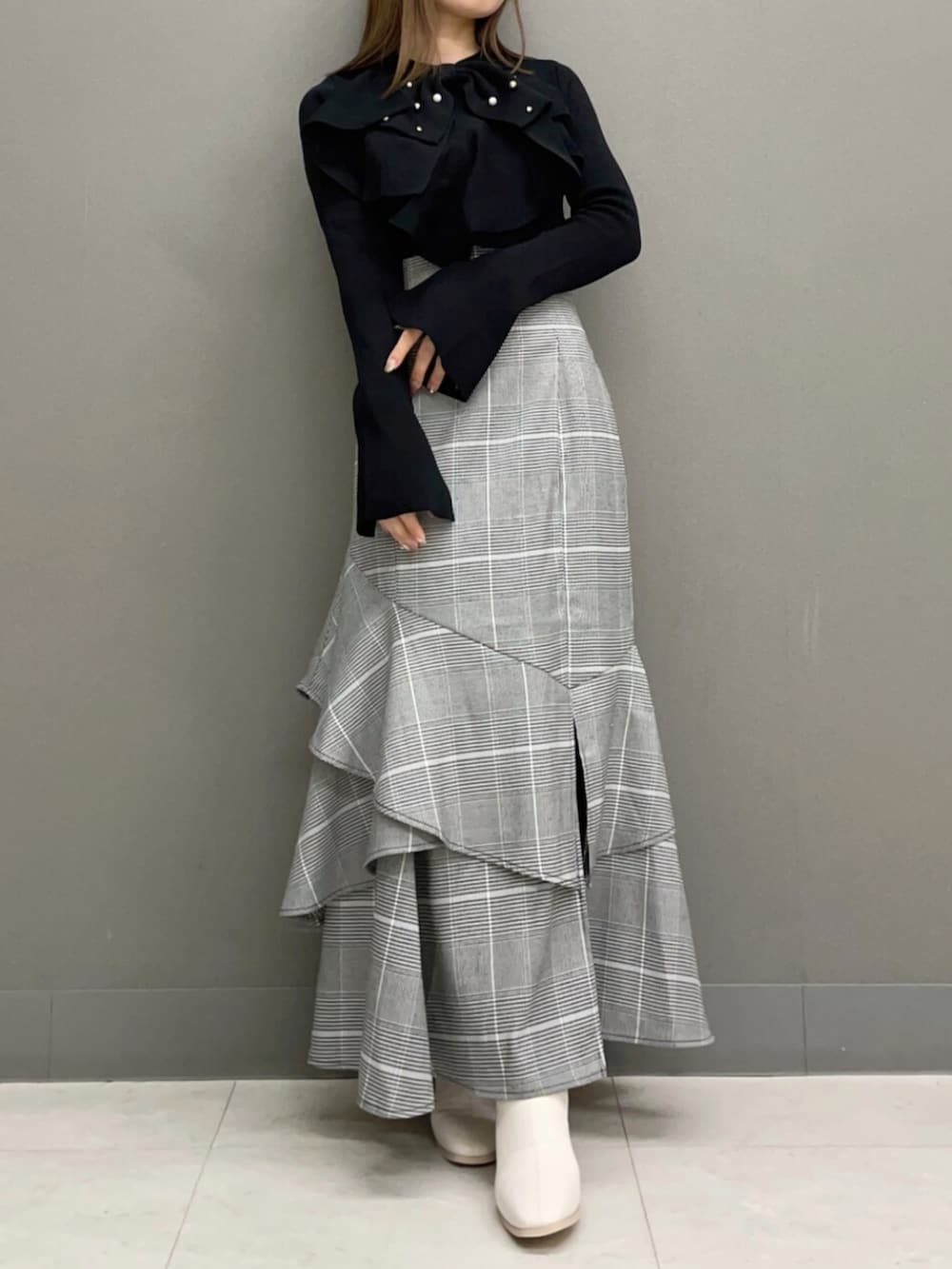 ホワイト系のブーツ、ブラック系のニット/セーター、その他のスカートを着用したレディースの秋コーディネートの3枚目の写真