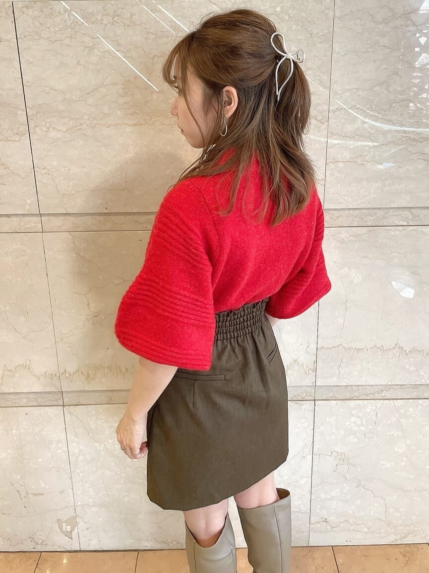 レッド系のニット/セーター、ブラウン系のスカート、ベージュ系のブーツを着用したレディースの秋コーディネートの8枚目の写真