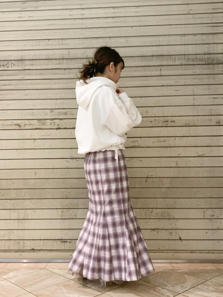 ホワイト系のパーカー、ベージュ系のブーツ、パープル系のスカートを着用したレディースの冬コーディネートの6枚目の写真