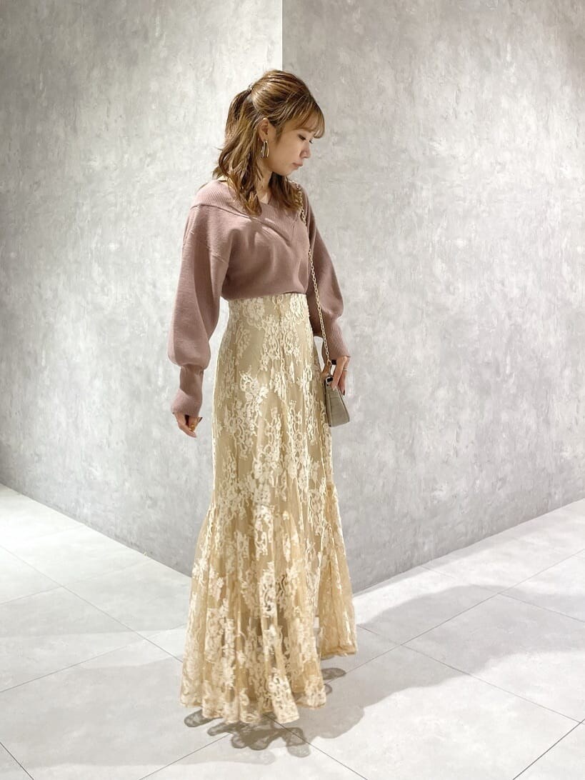 ピンク系のニット/セーター、ベージュ系のスカート、ベージュ系のスカートを着用したレディースの秋コーディネートの3枚目の写真