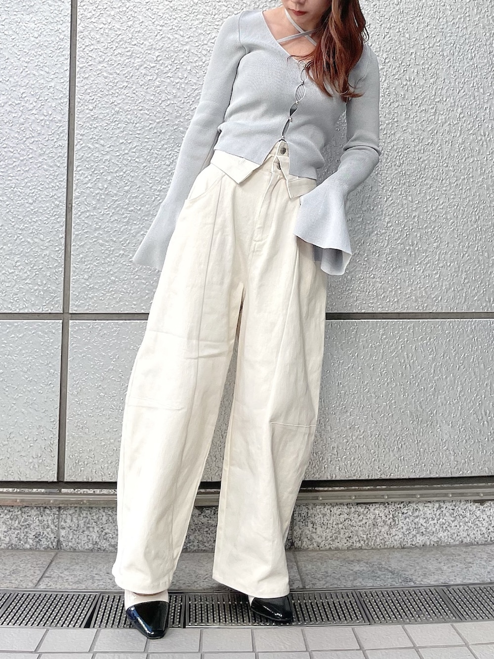 グレー系のニット/セーター、ホワイト系のデニムパンツ、その他のパンプスを着用したレディースの冬コーディネートの2枚目の写真