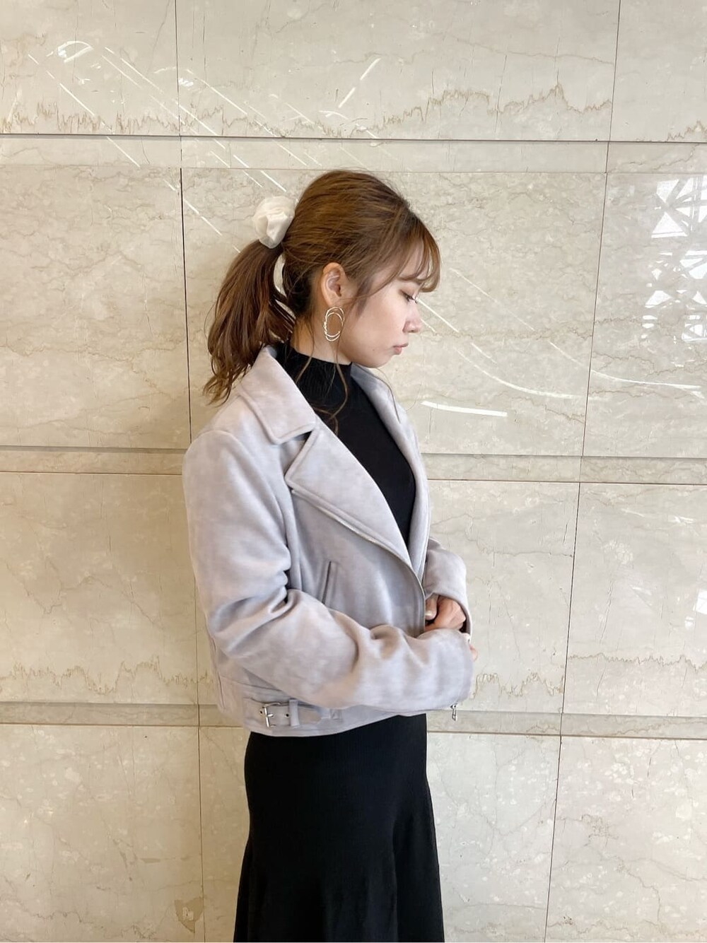 パープル系のライダースジャケット、ベージュ系のブーツ、ブラック系のワンピースを着用したレディースの秋コーディネートの5枚目の写真