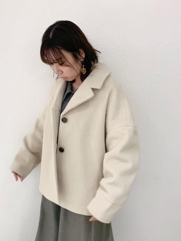 ホワイト系のその他アウター、グレー系のワンピース、ブラック系のブーツを着用したレディースの秋コーディネートの5枚目の写真
