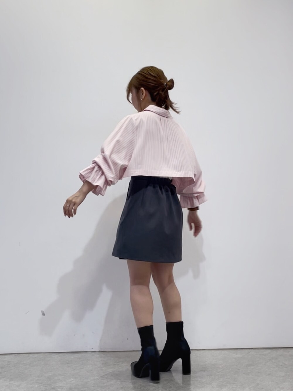 ピンク系のワンピース、グレー系のスカート、ブラック系のブーツを着用したレディースの春コーディネートの3枚目の写真