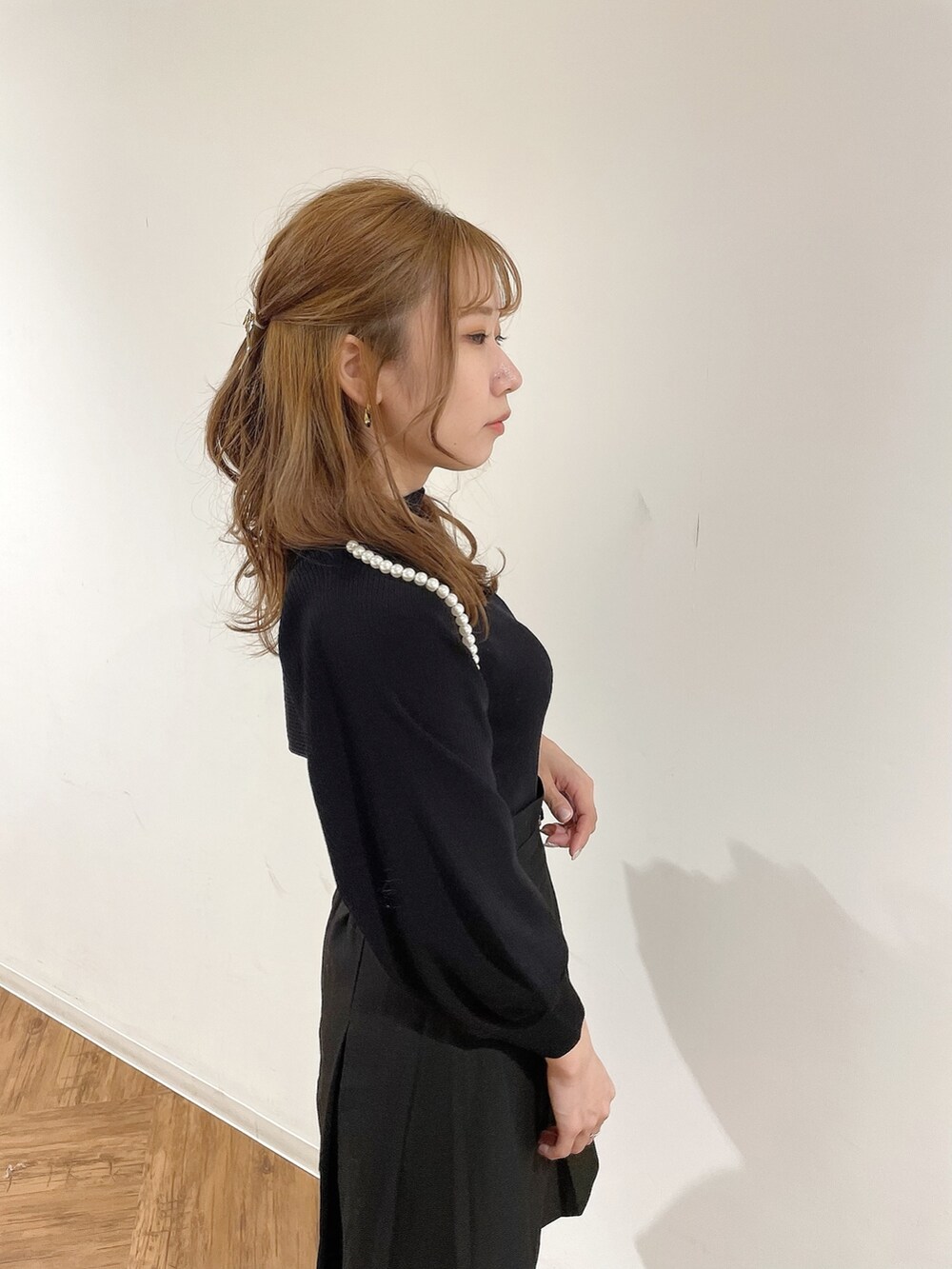 ブラック系のスカート、ブラック系のニット/セーター、ブラック系のブーツを着用したレディースの冬コーディネートの5枚目の写真