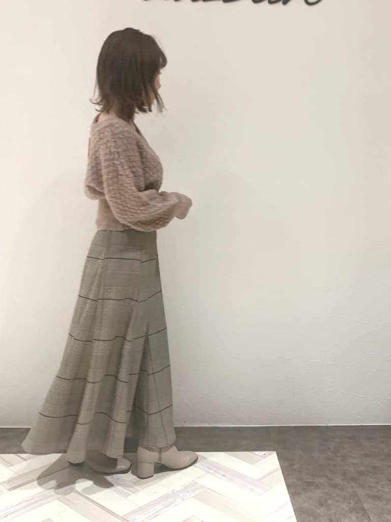 ブラウン系のスカート、ベージュ系のブーツ、ベージュ系のニット/セーターを着用したレディースの秋コーディネートの4枚目の写真