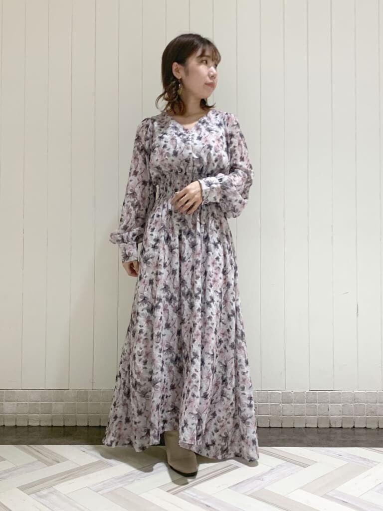 グレー系のトレンチコート、ピンク系のワンピース、ベージュ系のブーツを着用したレディースの秋コーディネートの5枚目の写真