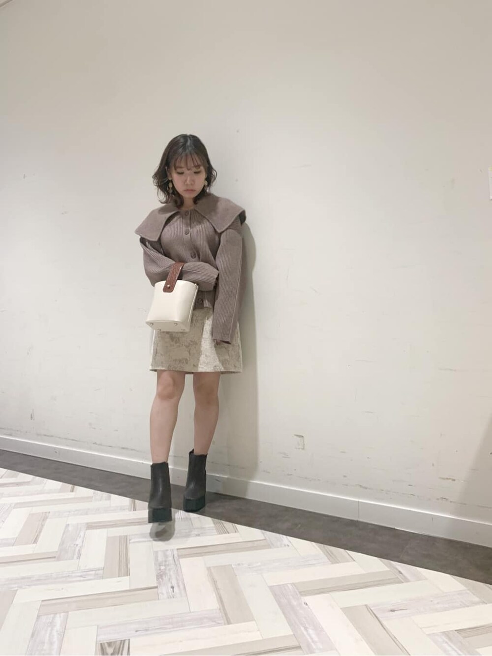 ブラウン系のブーツ、ベージュ系のニット/セーター、ベージュ系のスカートを着用したレディースの秋コーディネートの4枚目の写真