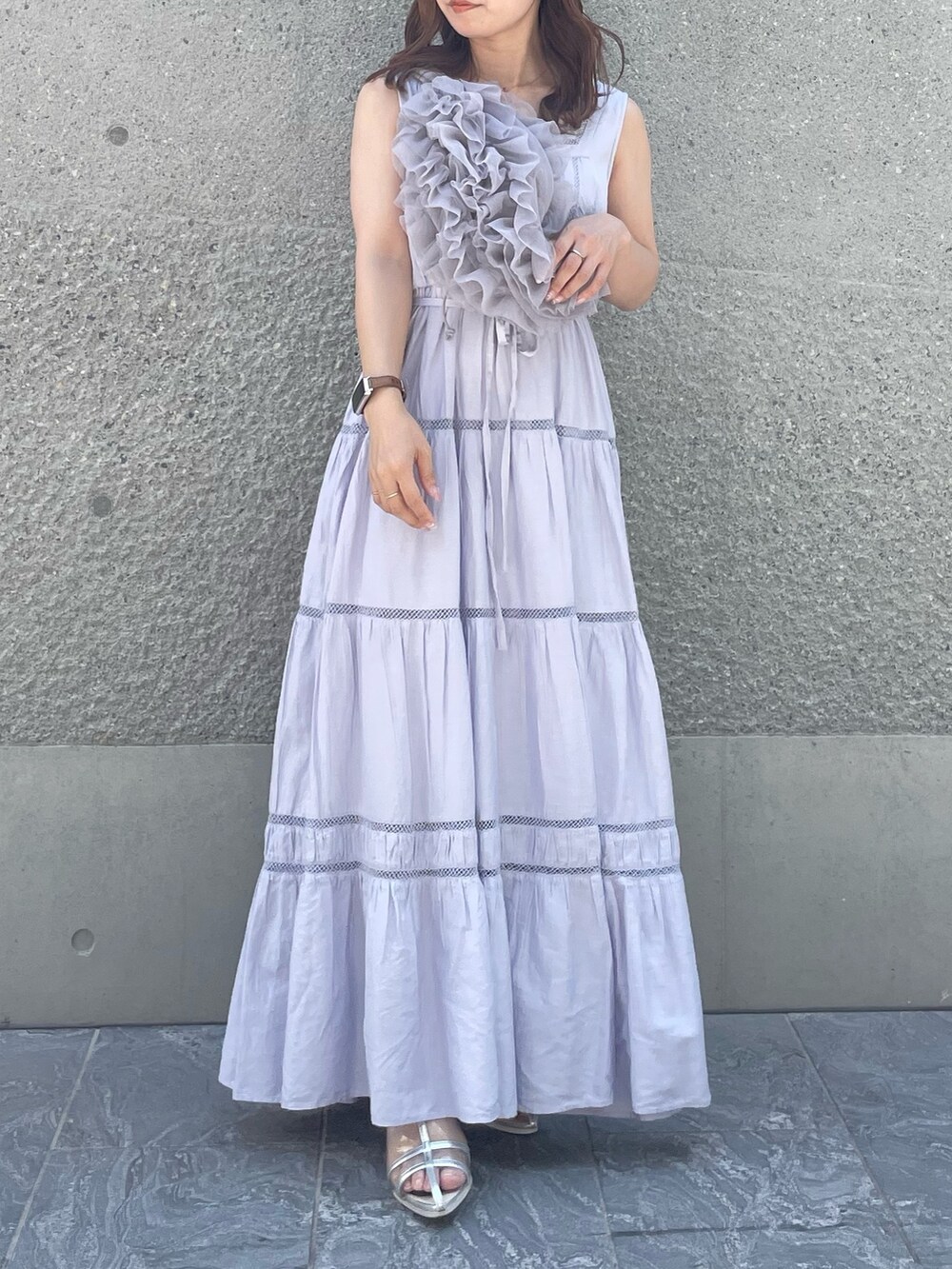 パープル系のベスト、パープル系のワンピース、シルバー系のパンプスを着用したレディースの夏コーディネートの4枚目の写真