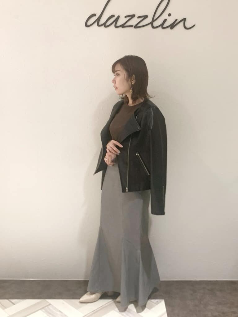 ホワイト系のパンプス、ブラック系のライダースジャケット、ブラック系のスカートを着用したレディースの秋コーディネートの4枚目の写真