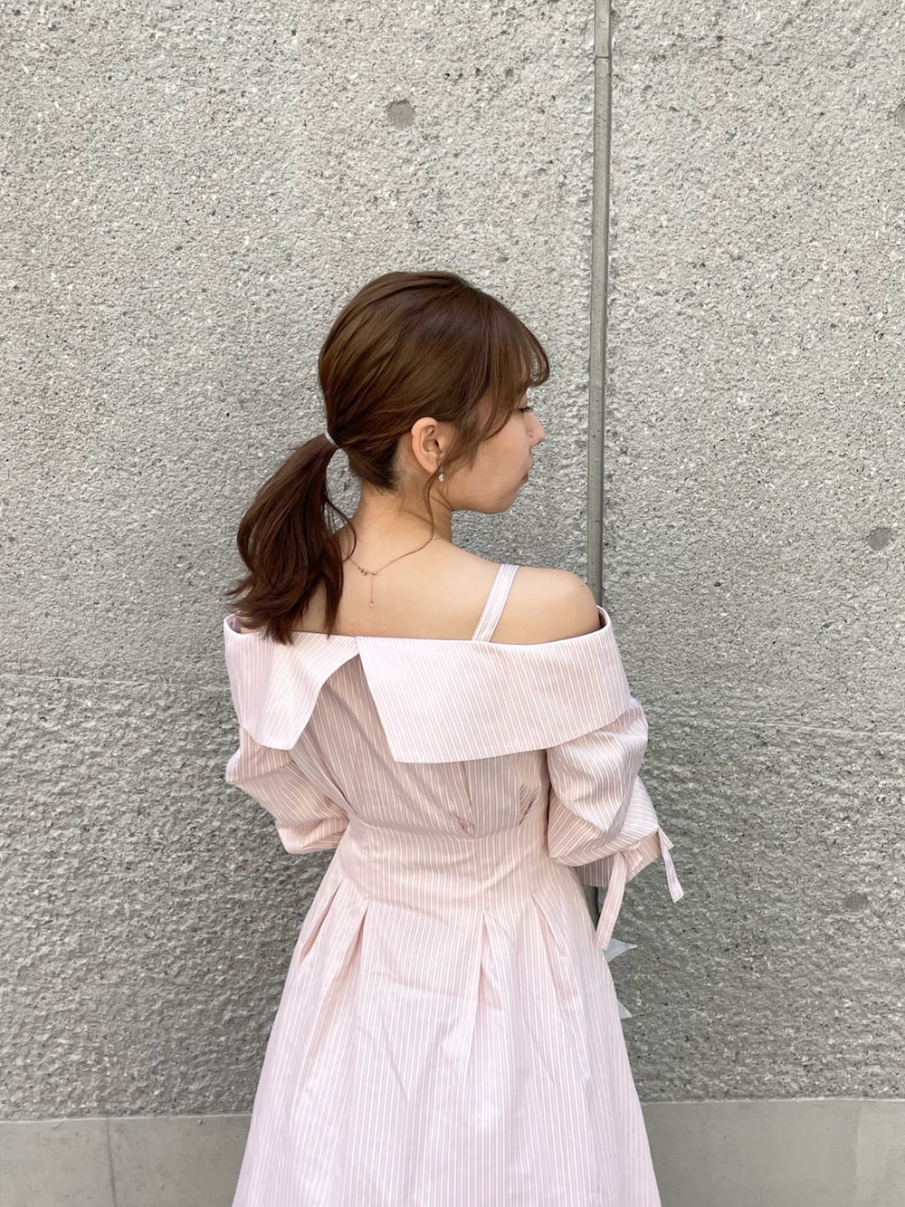 ピンク系のシャツワンピース、グレー系のベスト、ホワイト系のパンプスを着用したレディースの春コーディネートの6枚目の写真