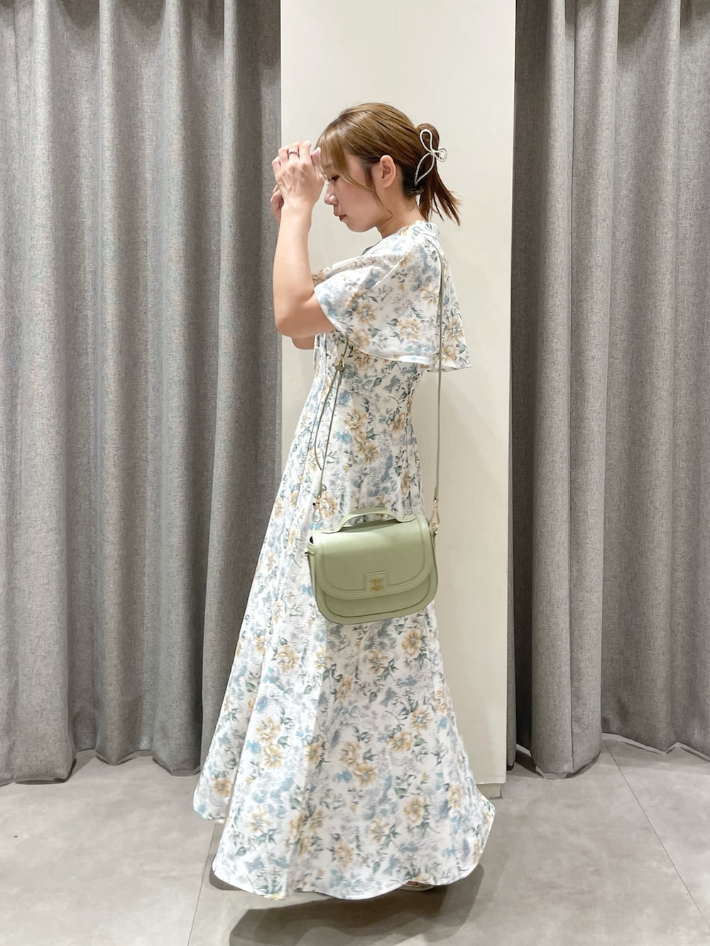 グリーン系のワンピース、グリーン系のハンドバッグ、シルバー系のパンプスを着用したレディースの夏コーディネートの2枚目の写真