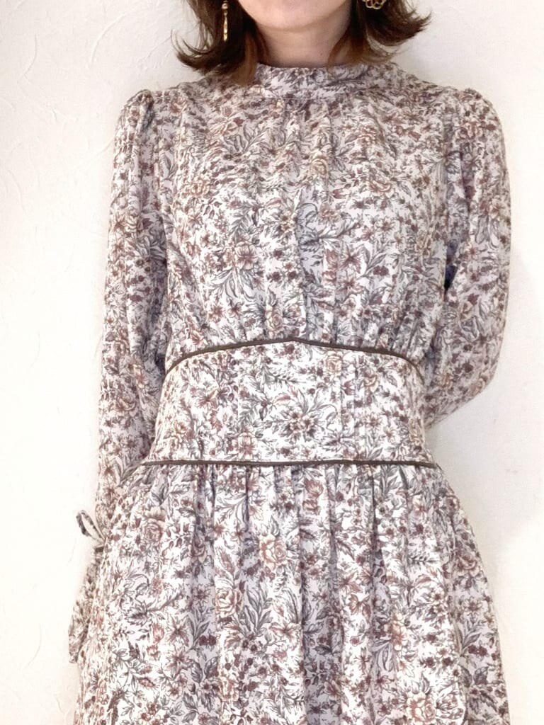 ブラウン系のワンピース、ベージュ系のブーツ、ブラウン系のバックパック/リュックを着用したレディースの秋コーディネートの2枚目の写真