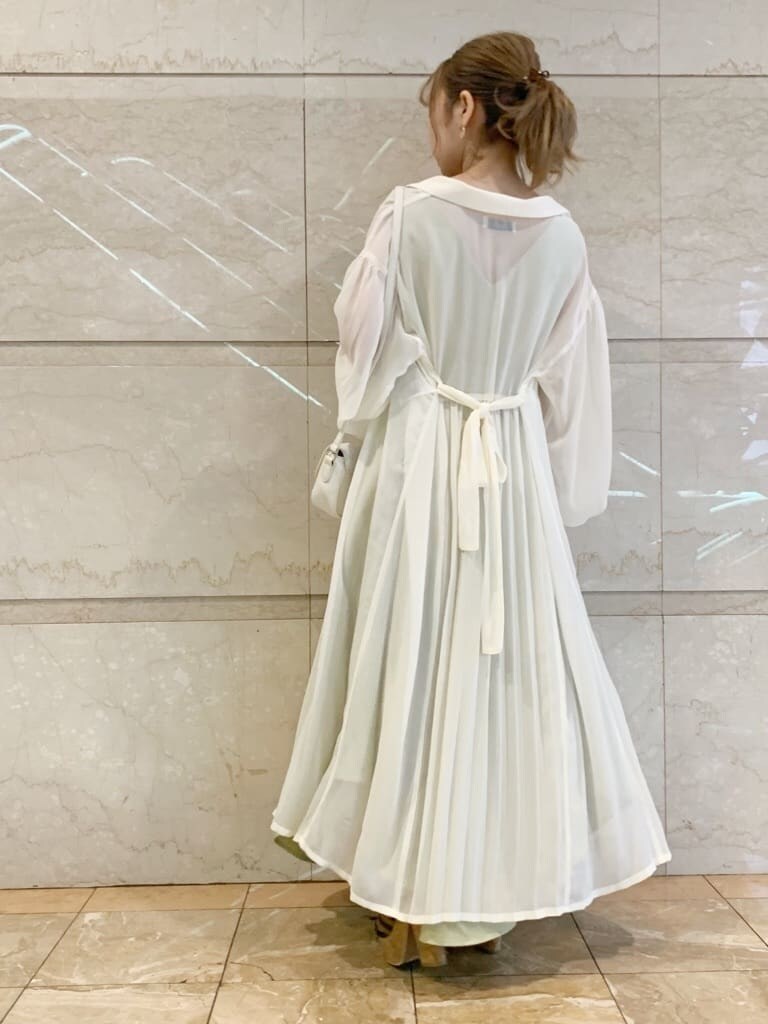 グリーン系のワンピース、ブラウン系のサンダル、ホワイト系のシャツ/ブラウスを着用したレディースの春コーディネートの7枚目の写真