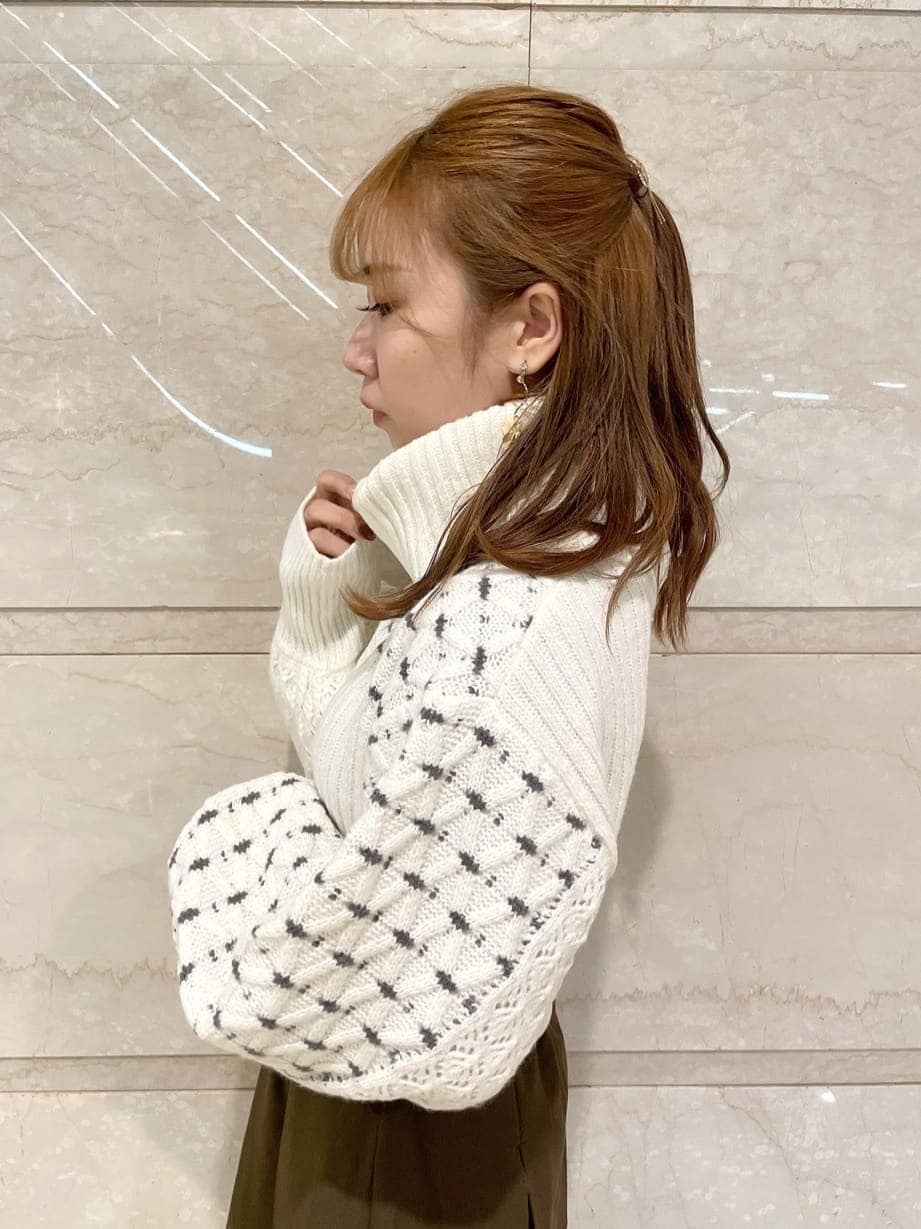 ブラウン系のスカート、ベージュ系のブーツ、ホワイト系のニット/セーターを着用したレディースの秋コーディネートの4枚目の写真