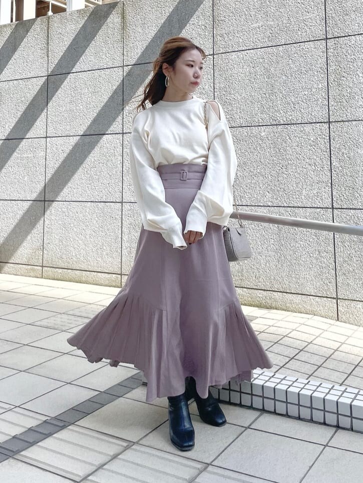 ベージュ系のスカート、ブラック系のブーツ、ホワイト系のキャミソールを着用したレディースの秋コーディネートの2枚目の写真