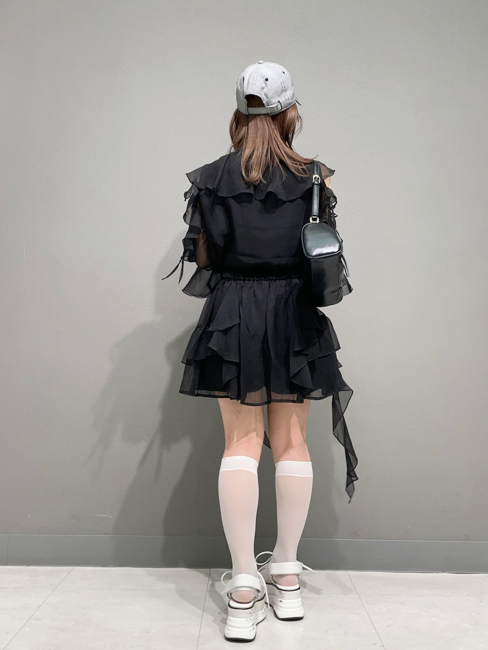 ブラック系のシャツ/ブラウス、ブラック系のスカート、ホワイト系のサンダルを着用したレディースの夏コーディネートの4枚目の写真