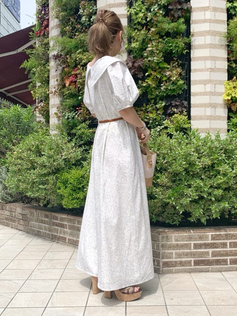 ベージュ系のハンドバッグ、ブラウン系のサンダル、ホワイト系のワンピースを着用したレディースの春コーディネートの3枚目の写真
