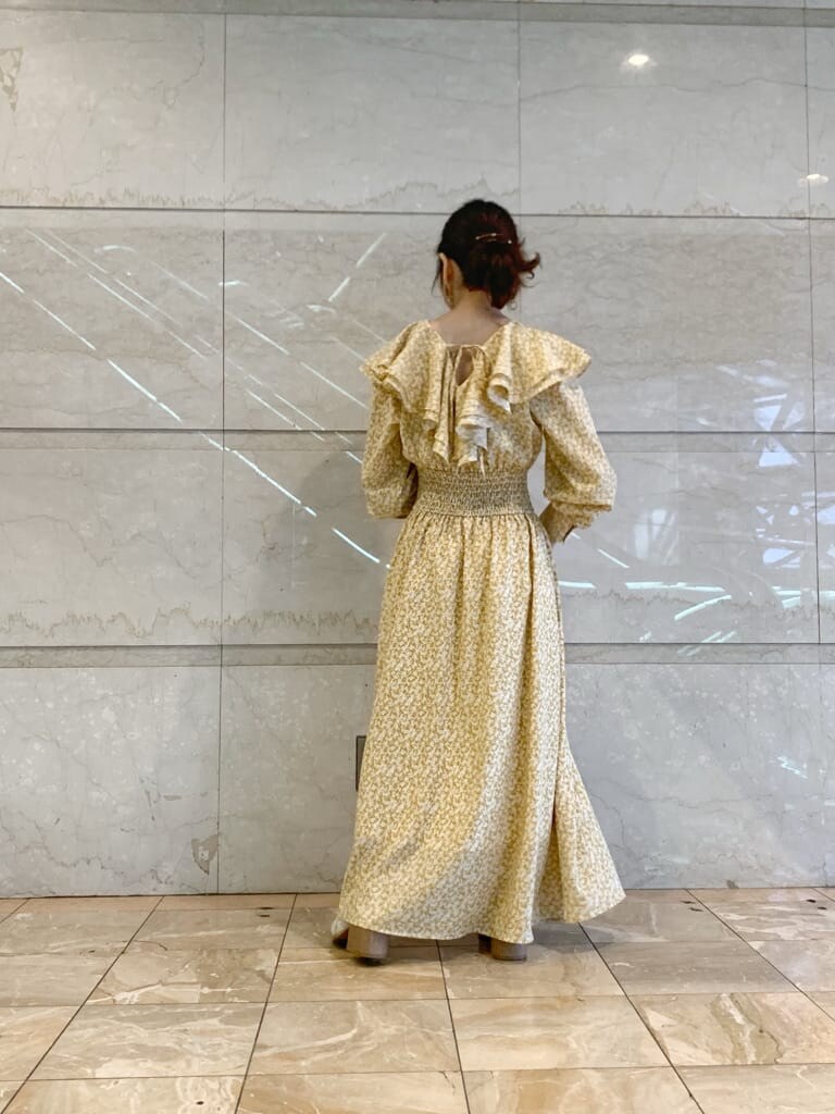 イエロー系のワンピース、ホワイト系のローファーを着用したレディースの冬コーディネートの4枚目の写真