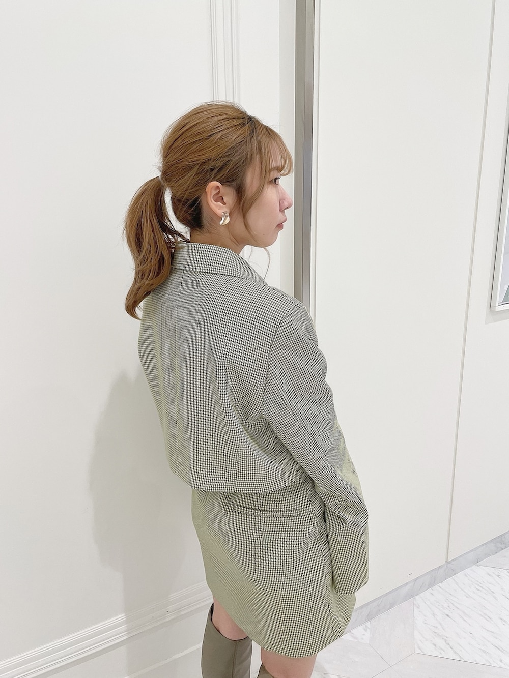 グリーン系のテーラードジャケット、ホワイト系のシャツ/ブラウス、グリーン系のスカートを着用したレディースの冬コーディネートの7枚目の写真